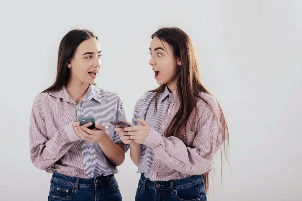 две близначки си говорят и си гледат телефоните